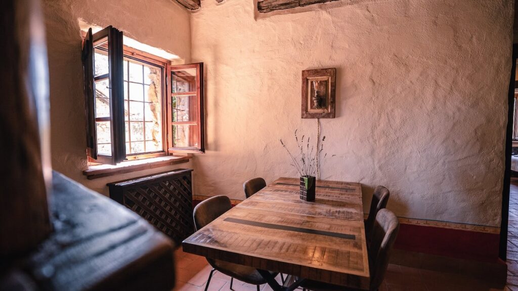 Living room with seating and a stone pillar in the Il cardinale apartment, Borgo Braila, Umbria