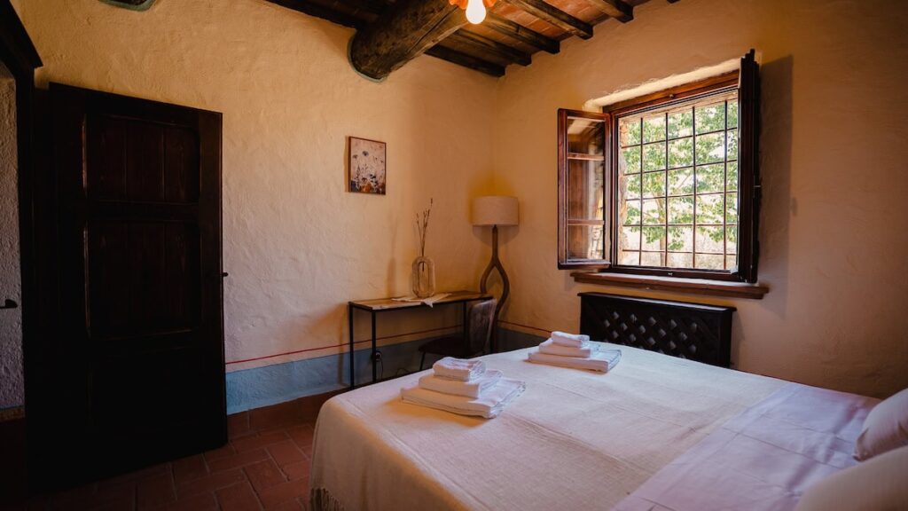Bedroom with a double bed and window in the Il cardinale apartment, Borgo Braila, Umbria