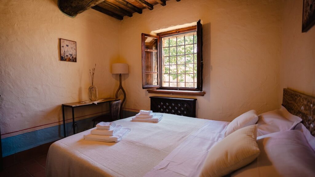 Bedroom with a double bed and window in the Il cardinale apartment, Borgo Braila, Umbria