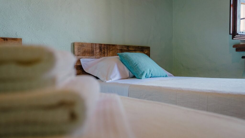 Twin beds with green throws in the Il cardinale apartment, Borgo Braila, Umbria