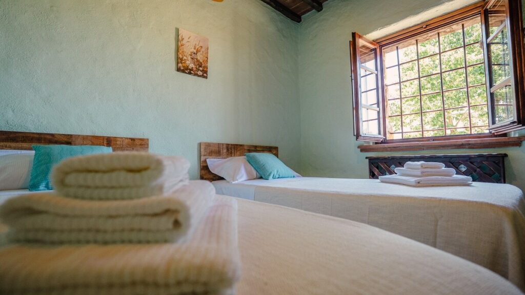 Twin bedroom with a window in the Il cardinale apartment, Borgo Braila, Umbria