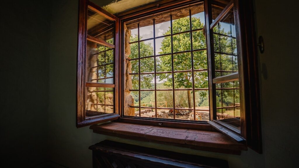 Bedroom window with a countryside view in the Il cardinale apartment, Borgo Braila, Umbria