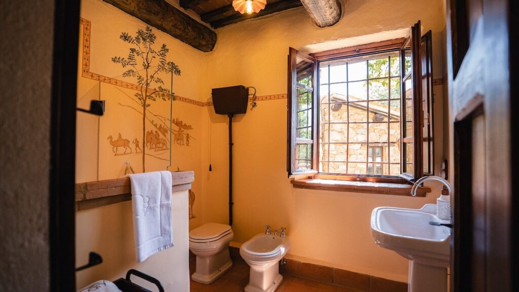 Bathroom with toilet and window in the Il cardinale apartment, Borgo Braila, Umbria