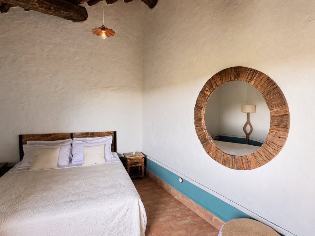 Bedroom with exposed beams and natural materials in the Il belvedere apartment, Borgo Braila