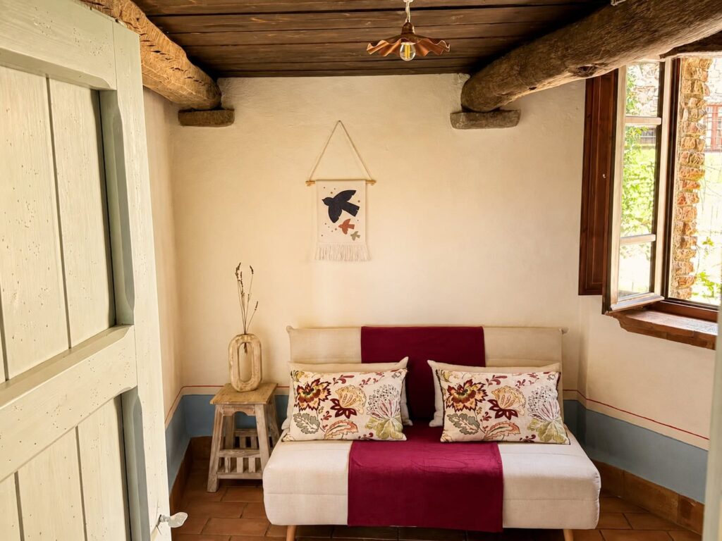 Bedroom with exposed beams and natural materials in a Borgo Braila apartment, Borgo Braila