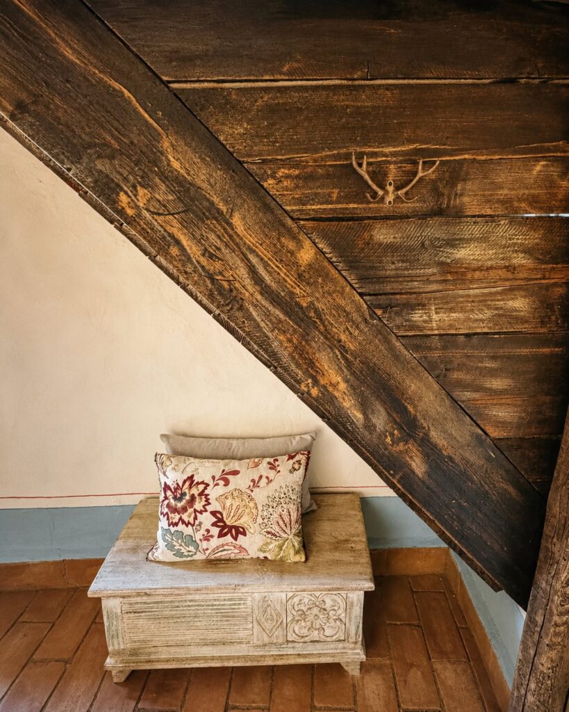 Bedroom with exposed beams and natural materials in a Borgo Braila apartment, Borgo Braila