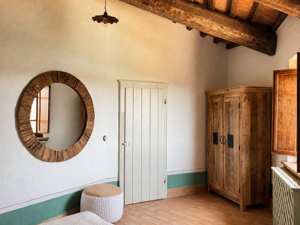 Bedroom with exposed beams and natural materials in a Borgo Braila apartment, Borgo Braila