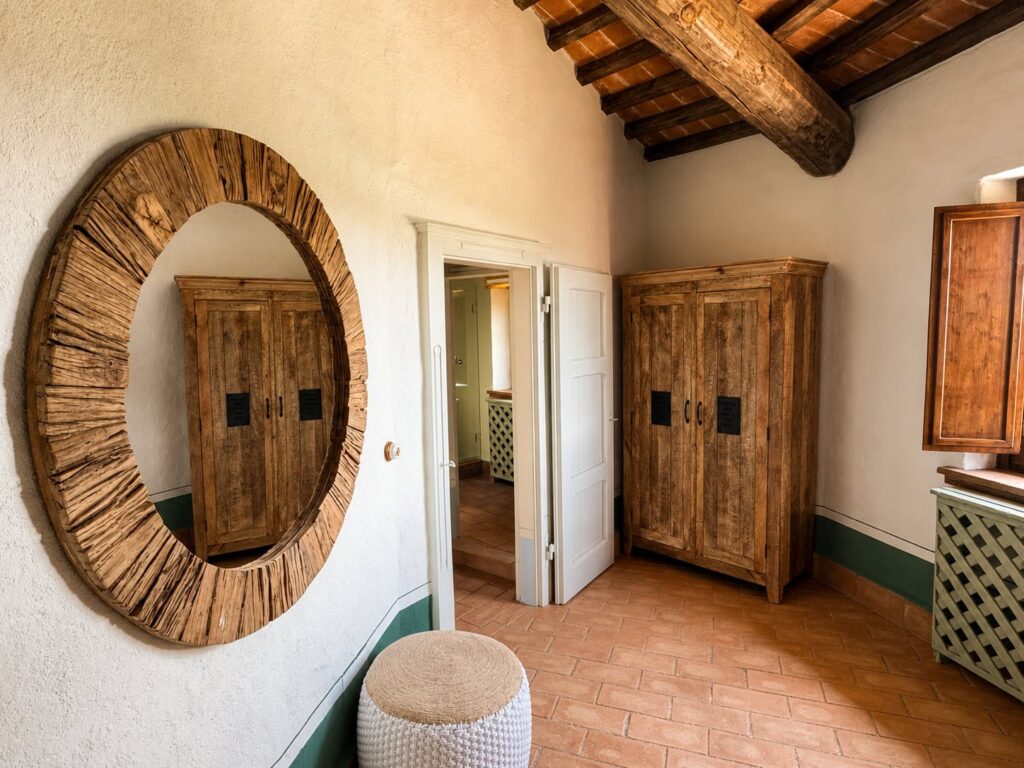 Bedroom with exposed beams and natural materials in a Borgo Braila apartment, Borgo Braila