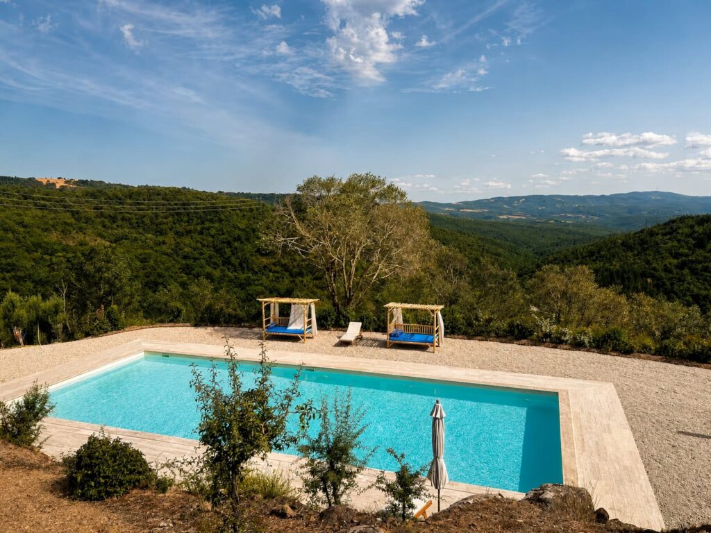 Panoramic travertine pool overlooking the Umbrian hills at Borgo Braila