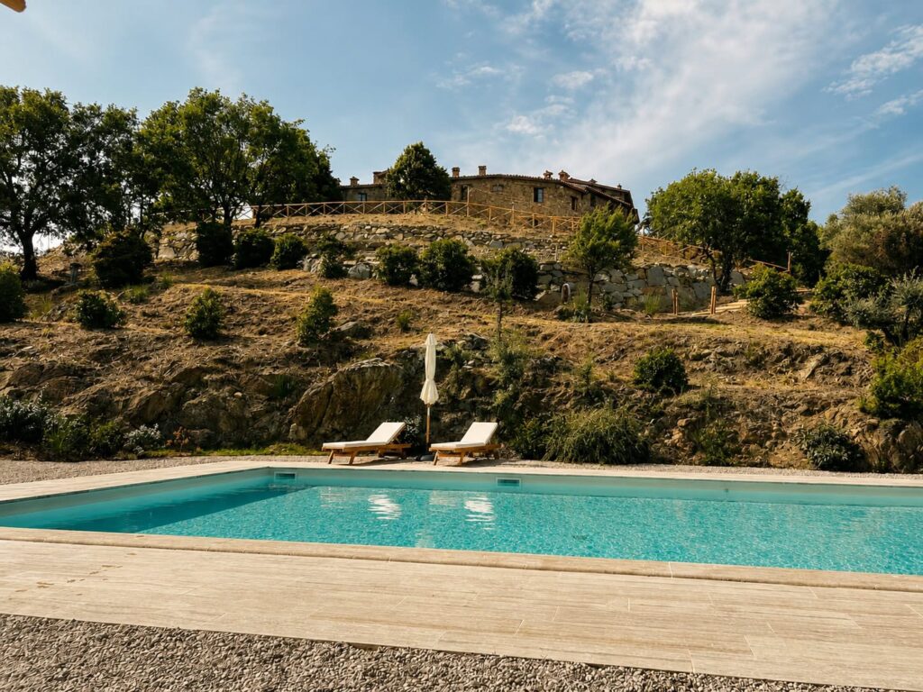 Panoramic travertine pool overlooking the Umbrian hills at Borgo Braila