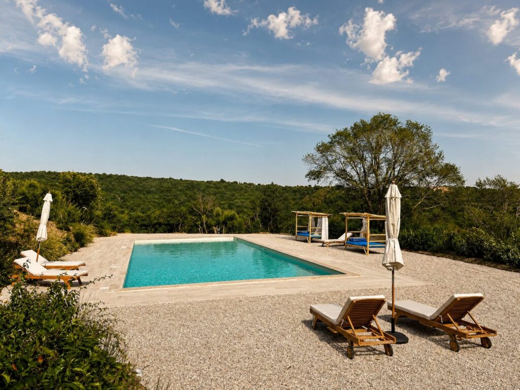 Panoramic travertine pool overlooking the Umbrian hills at Borgo Braila