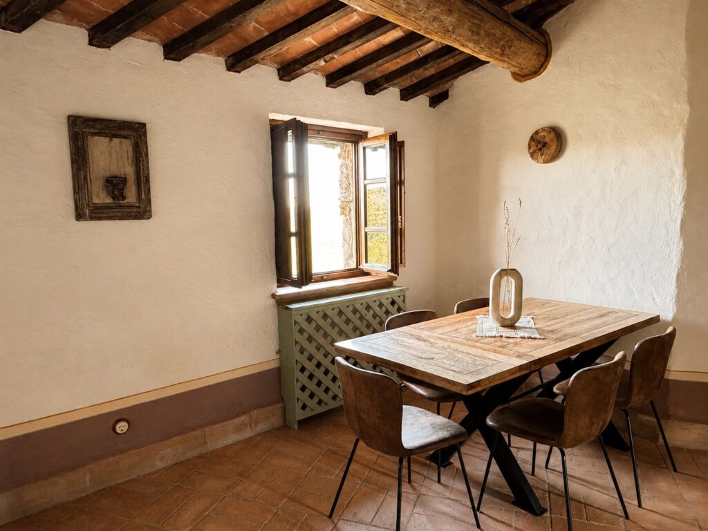 Dining area with exposed beams in the Il belvedere apartment at Borgo Braila