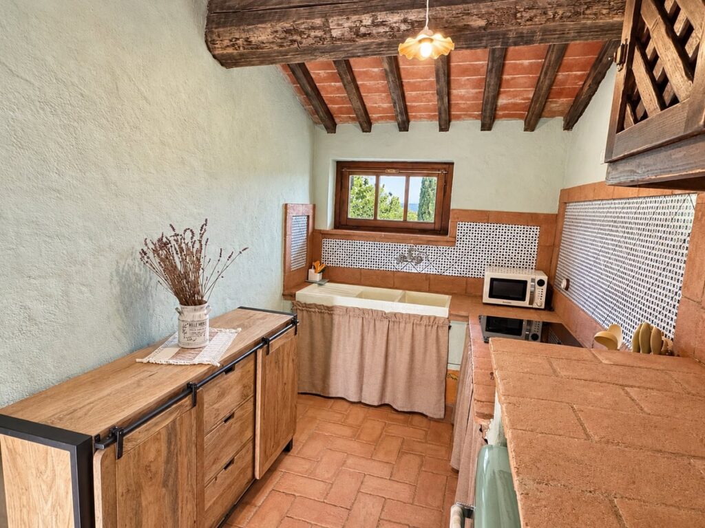 Kitchen with a wooden sideboard and tiled splashback in the La Dimora del Levante apartment, Borgo Braila, Umbria