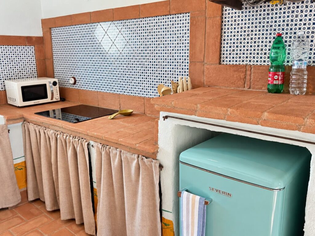 Kitchen counter with blue tiles and a retro fridge in the La Dimora del Levante apartment, Borgo Braila, Umbria