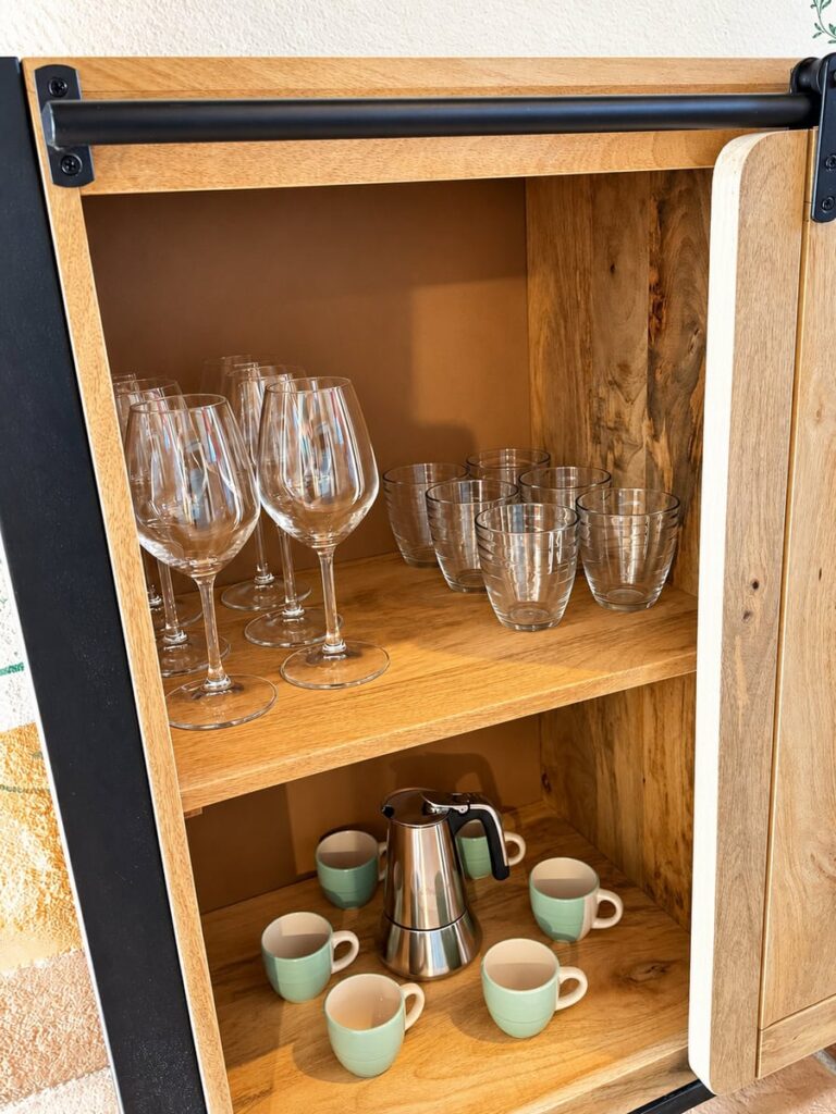 Open cabinet with glasses and cups in the La Dimora del Levante apartment, Borgo Braila, Umbria