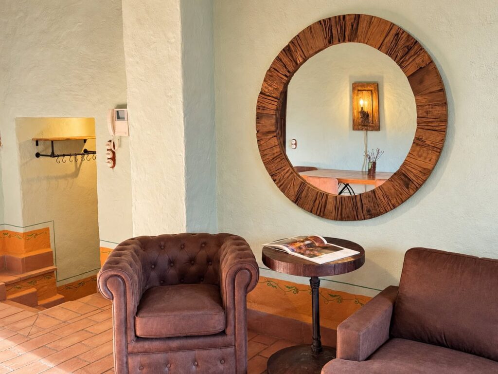 Sitting area with armchairs and a round mirror in the La Dimora del Levante apartment, Borgo Braila, Umbria